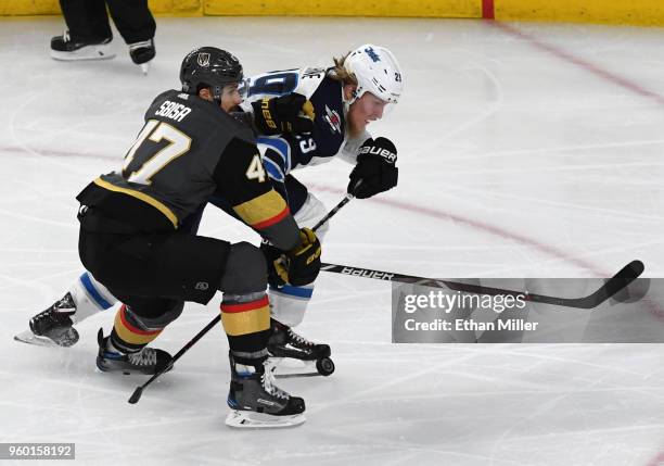 Patrik Laine of the Winnipeg Jets skates with the puck against Luca Sbisa of the Vegas Golden Knights in the first period of Game Four of the Western...