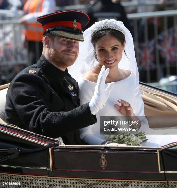 Prince Harry, Duke of Sussex and Meghan, Duchess of Sussex wave from the Ascot Landau Carriage during their carriage procession on Castle Hill...