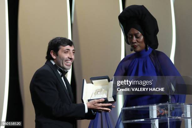 Italian actor Marcello Fonte delivers a speech on stage next to Burundian singer and member of the Feature Film Jury Khadja Nin on May 19, 2018 after...