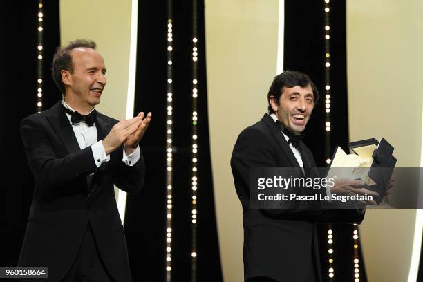Roberto Benigni (L stands by as actor Marcello Fonte receives the Best Actor award for his role in 'Dogman' on stage during the Closing Ceremony at...
