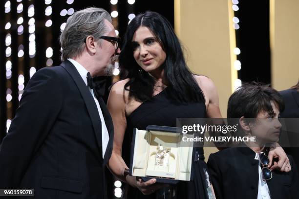 Lebanese director and actress Nadine Labaki speaks on stage with British actor Gary Oldman next to Syrian actor Zain al-Rafeea after she was awarded...