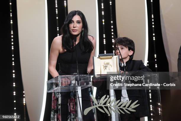 Actor Zain Alrafeea looks on as Director Nadine Labaki receives the Jury Prize award for 'Capharnaum' on stage during the Closing Ceremony at the...