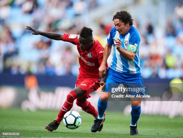 Manuel Rolando Iturra of Malaga CF duels for the ball withgt Amath Ndiaye of Getafe CF during the La Liga match between Malaga CF and Getafe CF at...