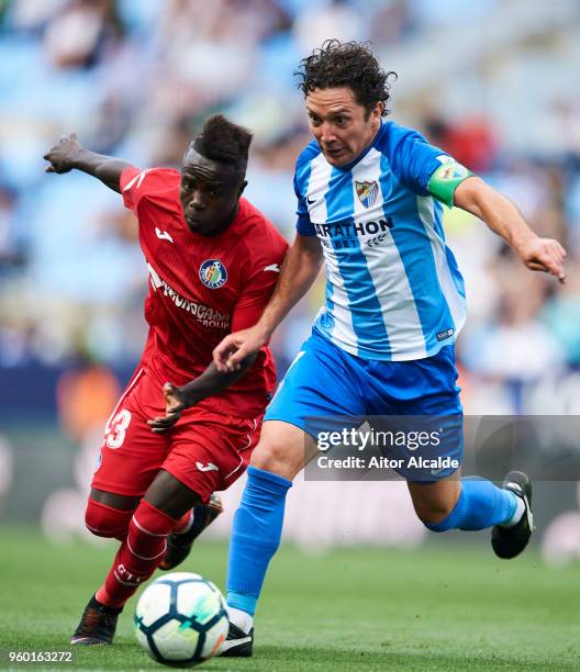 Manuel Rolando Iturra of Malaga CF duels for the ball withgt Amath Ndiaye of Getafe CF during the La Liga match between Malaga CF and Getafe CF at...