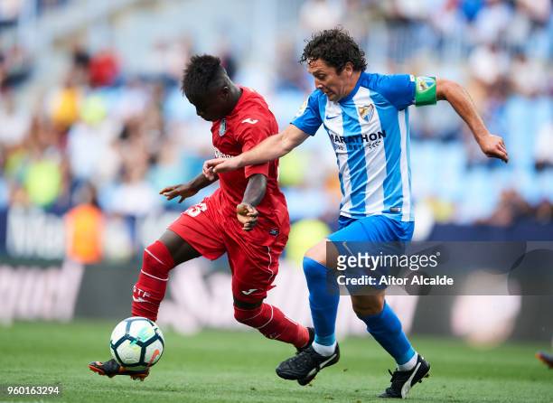 Manuel Rolando Iturra of Malaga CF duels for the ball withgt Amath Ndiaye of Getafe CF during the La Liga match between Malaga CF and Getafe CF at...