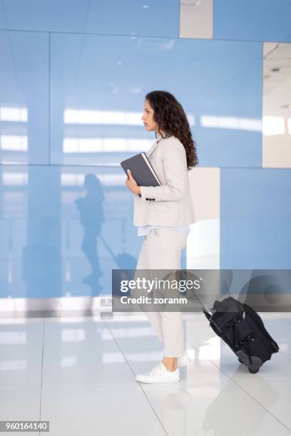 mujer de negocios en el aeropuerto - arab businesswoman with books fotografías e imágenes de stock