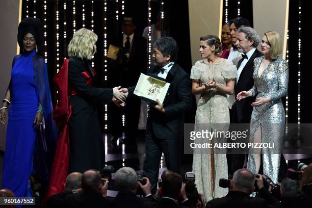 Japanese director Hirokazu Kore-Eda shakes hands with Australian actress and President of the Jury Cate Blanchett , as he poses on stage with...