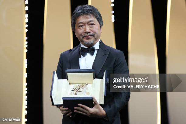 Japanese director Hirokazu Kore-Eda poses on stage after he was awarded with the Palme d'Or for the film "Shoplifters " on May 19, 2018 during the...