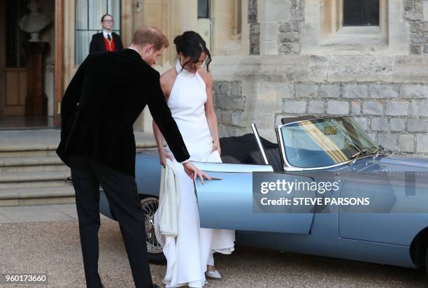 Britain's Prince Harry, Duke of Sussex, opens the passenger door of an E-Type Jaguar car for his wife Meghan Markle, Duchess of Sussex, as they leave...