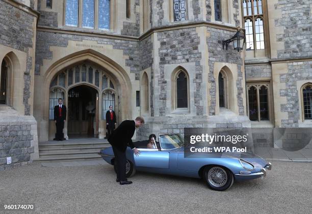 Prince Harry, Duke of Sussex helps his new bride the Duchess of Sussex into the car as they leave Windsor Castle after their wedding to attend an...