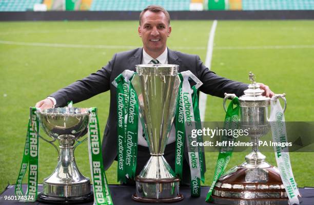 Celtic manager Brendan Rodgers poses with the three trophies during the parade at Celtic Park, Glasgow.