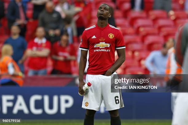 Manchester United's French midfielder Paul Pogba reacts to their defeat on the pitch after the English FA Cup final football match between Chelsea...