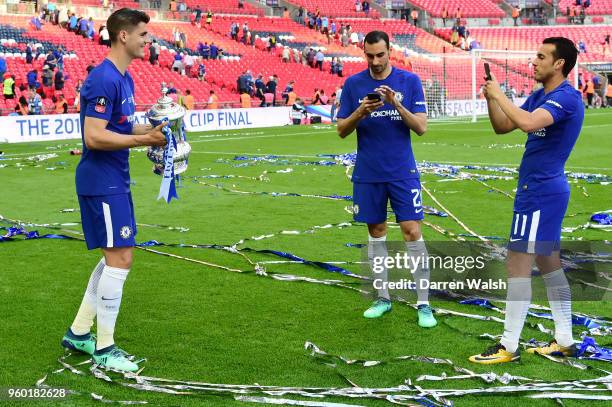 Alvaro Morata of Chelsea poses with the Emirates FA Cup trophy whilst Davide Zappacosta and Pedro of Chelsea take photos, following their victory...