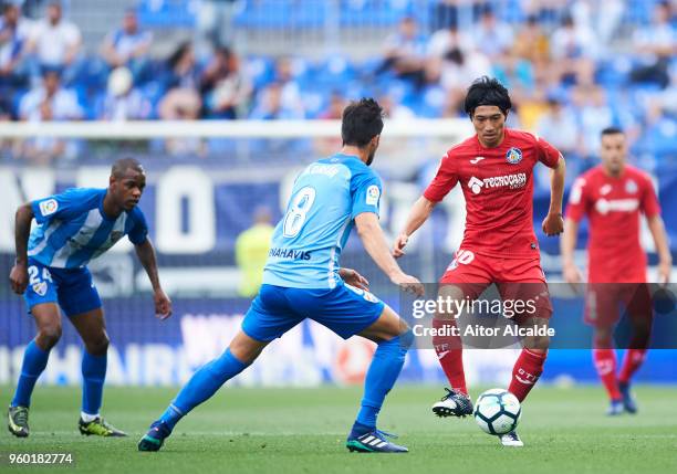 Adrian Gonzalez of Malaga CF duels for the ball with Gaku Shibasaki of Getafe CF during the La Liga match between Malaga CF and Getafe CF at Estadio...