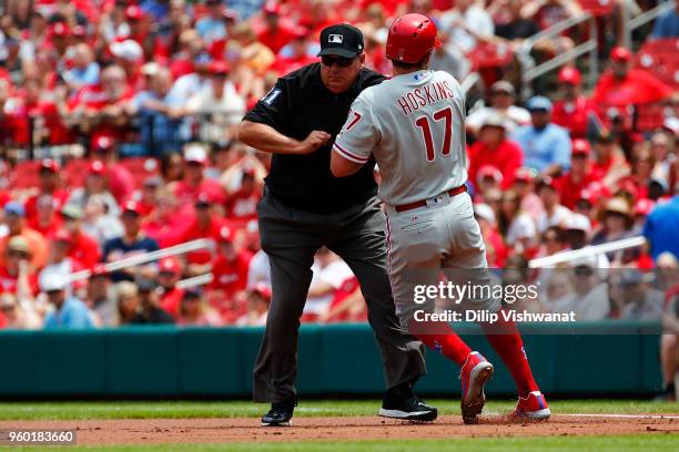 Rhys Hoskins of the Philadelphia Phillies runs into umpire Larry Vanover as he rounds first base against the St. Louis Cardinals in the first inning...