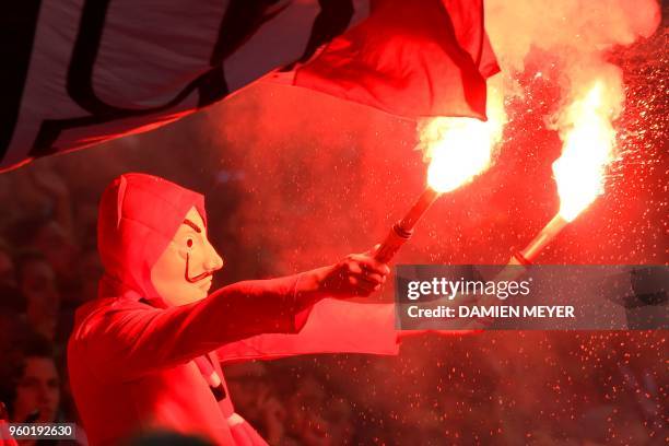 Rennes 'supporter uses holds up lit flares during the French L1 football match Rennes against Montpellier on May 19, 2018 at the Roazhon Park stadium...