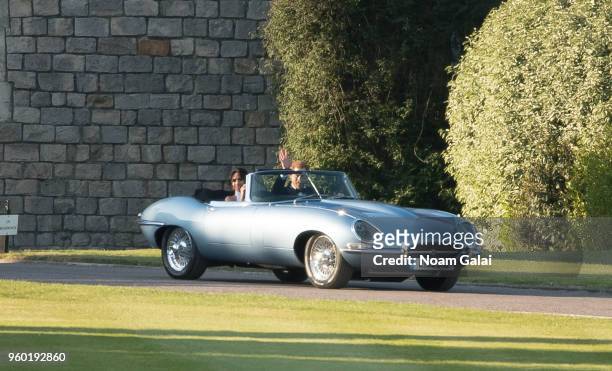 Prince Harry, Duke of Sussex, and Meghan Markle, Duchess of Sussex, leave Windsor Castle in Windsor on May 19, 2018 in an E-Type Jaguar after their...