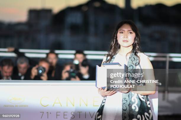 Kazakh actress Samal Yeslyamova poses with her trophy on May 19, 2018 during a photocall after she won the Best Actress Prize for her part in "Ayka "...