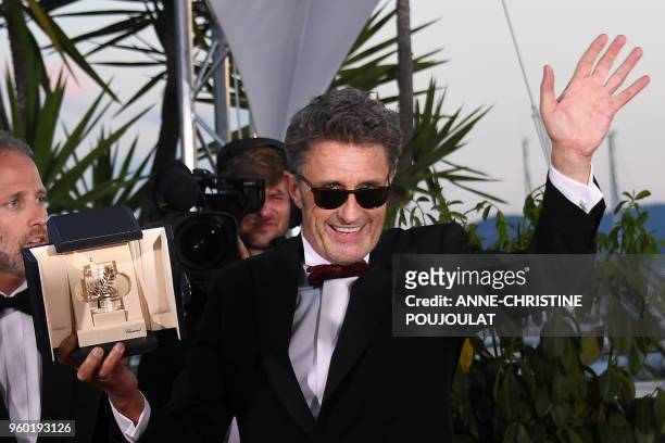 Polish director Pawel Pawlikowski poses with the trophy on May 19, 2018 during a photocall after he won the Best Director prize for the film "Zimna...