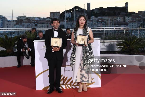 Italian actor Marcello Fonte and Kazakh actress Samal Yeslyamova pose with their trophies on May 19, 2018 during a photocall after they won the Best...