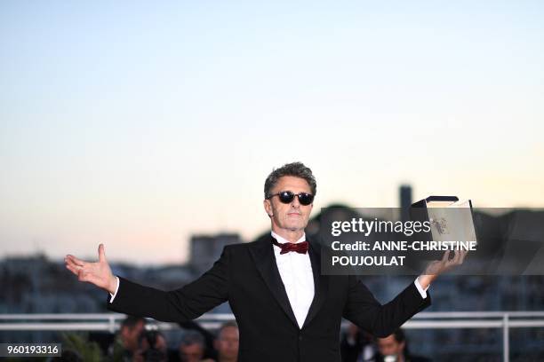 Polish director Pawel Pawlikowski poses with the trophy on May 19, 2018 during a photocall after he won the Best Director prize for the film "Zimna...