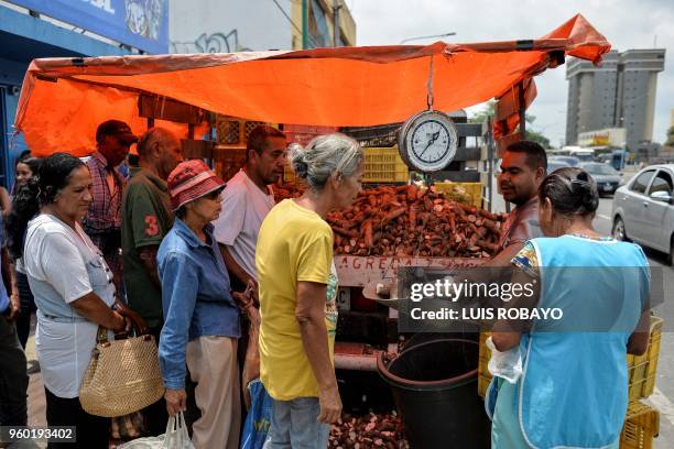 People buy vegetables at a street stall in Barquisimeto, Venezuela, on May 19, 2018 on the eve of the country's presidential election. - Venezuela...