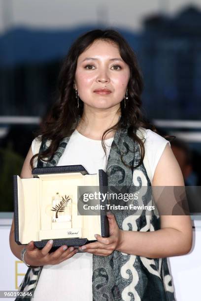 Actress Samal Yeslyamova poses with the Best Actress award for her role in 'Ayka' at the photocall the Palme D'Or Winner during the 71st annual...