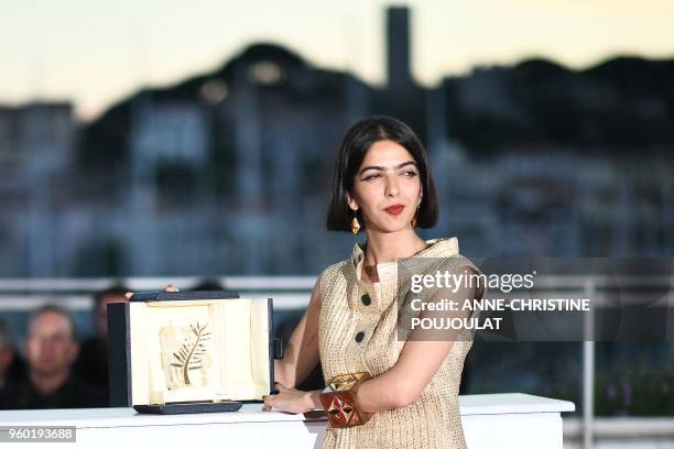 Iranian actress and daughter of Jafar Panahi Solmaz Panahi poses with the trophy on May 19, 2018 during a photocall after her father jointly won the...