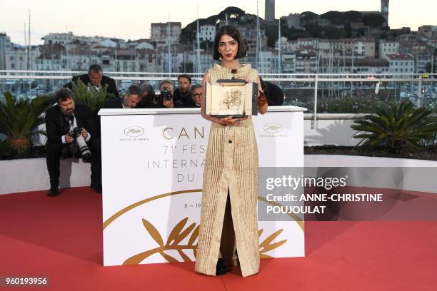 Iranian actress and daughter of Jafar Panahi Solmaz Panahi poses with the trophy on May 19, 2018 during a photocall after her father jointly won the...