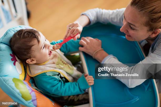 mother feeding her baby boy - thanasis zovoilis stock pictures, royalty-free photos & images