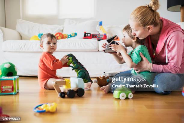 3 year old boy taking photo of his brother - thanasis zovoilis stock pictures, royalty-free photos & images