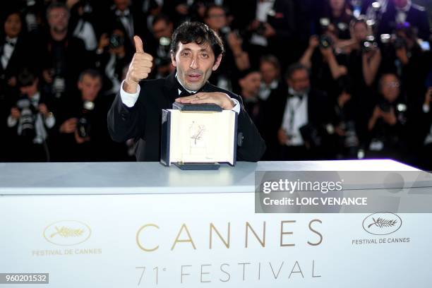 Italian actor Marcello Fonte poses with the trophy on May 19, 2018 during a photocall after he won the Best Actor Prize for his part in "Dogman" at...