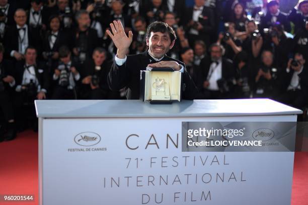 Italian actor Marcello Fonte poses with the trophy on May 19, 2018 during a photocall after he won the Best Actor Prize for his part in "Dogman" at...