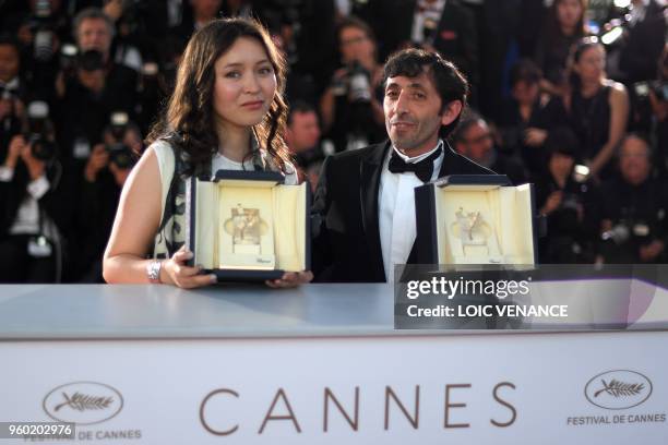 Italian actor Marcello Fonte and Kazakh actress Samal Yeslyamova pose with their trophies on May 19, 2018 during a photocall after they won the Best...