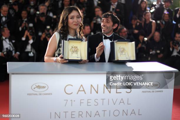 Italian actor Marcello Fonte and Kazakh actress Samal Yeslyamova pose with their trophies on May 19, 2018 during a photocall after they won the Best...