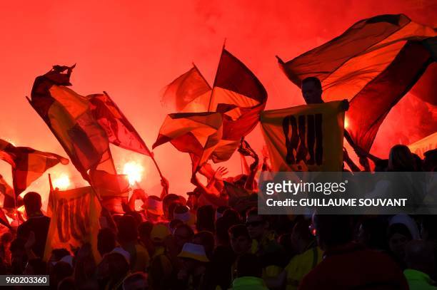 Nantes supporters wave flags during the French L1 football match between RC Strasbourg Alsace and Nantes FC at La Baujoire Stadium, in Nantes,...