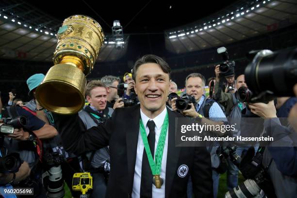 Head coach of Eintracht Frankfurt Niko Kovac lifts the DFB Cup trophy after winning the DFB Cup final against Bayern Muenchen at Olympiastadion on...