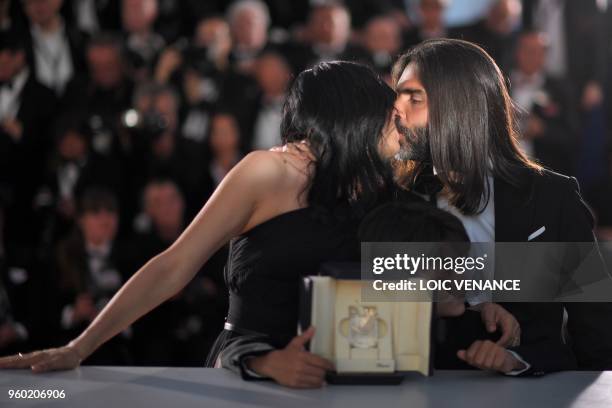 Lebanese director and actress Nadine Labaki and her husband Lebanese producer Khaled Mouzanar kiss as and Syrian actor Zain al-Rafeea poses with the...