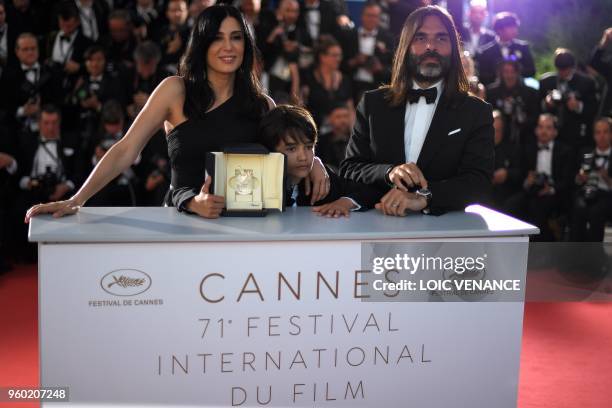 Lebanese director and actress Nadine Labaki , her husband Lebanese producer Khaled Mouzanar and Syrian actor Zain al-Rafeea pose with the trophy on...