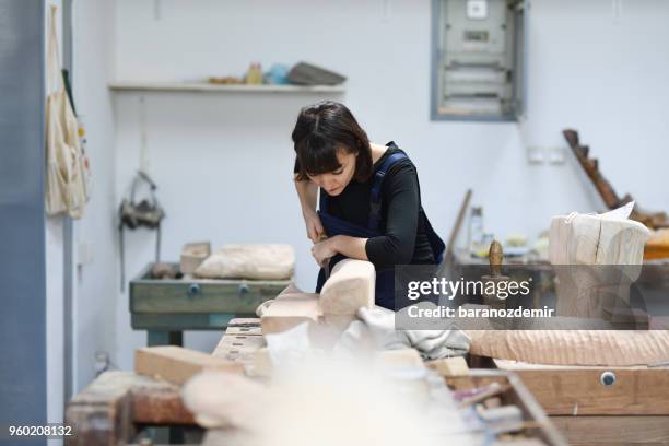 jeune femme sculpteur travaille dans son atelier - couteau à découper photos et images de collection