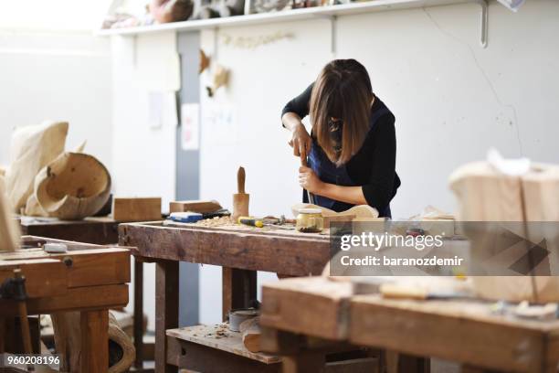 jeune femme sculpteur travaille dans son atelier - couteau à découper photos et images de collection