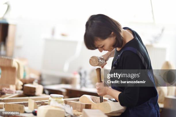 young female sculptor is working in her studio - carving knife imagens e fotografias de stock