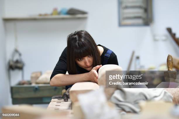 young female sculptor is working in her studio - carving knife imagens e fotografias de stock