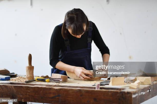 jeune femme sculpteur travaille dans son atelier - couteau à découper photos et images de collection