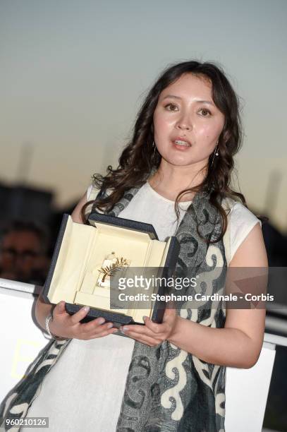 Actress Samal Yeslyamova poses with the Best Actress award for her role in 'Ayka' at the Palme D'Or Winner Photocall during the 71st annual Cannes...