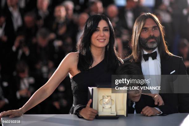 Lebanese director and actress Nadine Labaki , her husband Lebanese producer Khaled Mouzanar and Syrian actor Zain al-Rafeea pose with the trophy on...