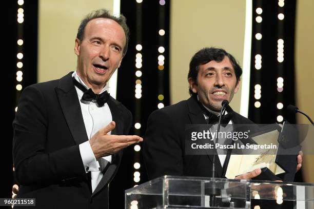 Roberto Benigni stands by as actor Marcello Fonte receives the Best Actor award for his role in 'Dogman' on stage during the Closing Ceremony at the...