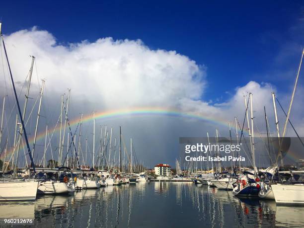 yachts docked in harbor with rainbow over them - isabel pavia stockfoto's en -beelden