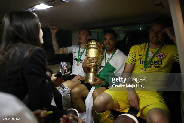Marius Wolf of Frankfurt, Marco Fabian of Frankfurt and Lukas Hradecky of Frankfurt sit in a care with the trophy after the DFB Cup final between...