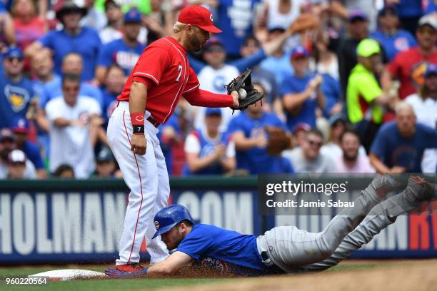 Ian Happ of the Chicago Cubs slides in for a triple as Eugenio Suarez of the Cincinnati Reds takes the throw in the sixth inning at Great American...